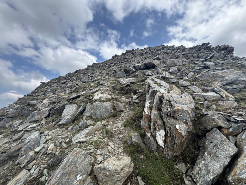 Close-up view of rocky scramble section near the summit while climbing Barrclashcame, showing jagged stone and steep incline.