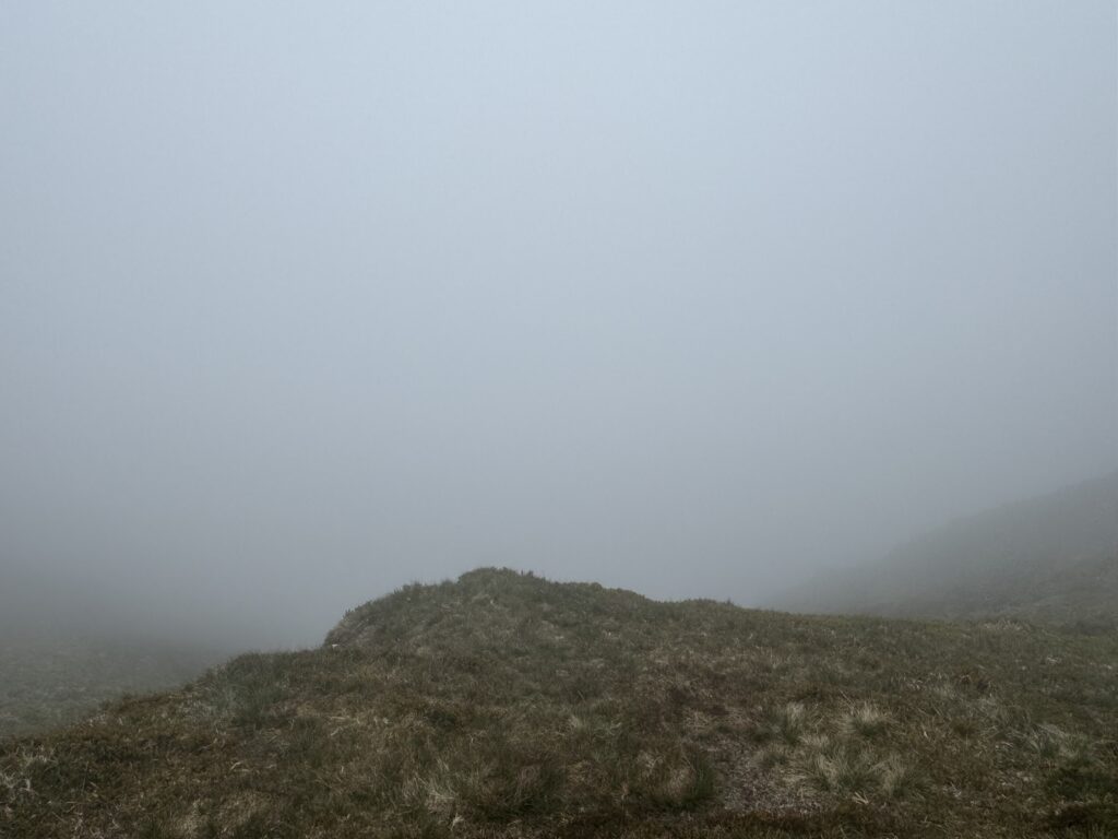 An abyss of cloud beyond a cliff edge.