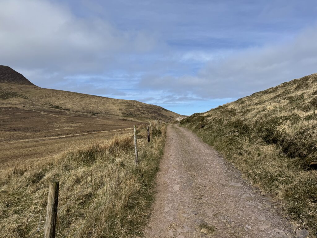 Gravel hiking track winding between the open slopes of the Mount Brandon Range on the Dingle Peninsula.