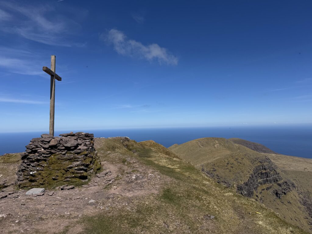 Summit cross and stone structure on Mount Brandon with Atlantic views along the Mount Brandon Loop.